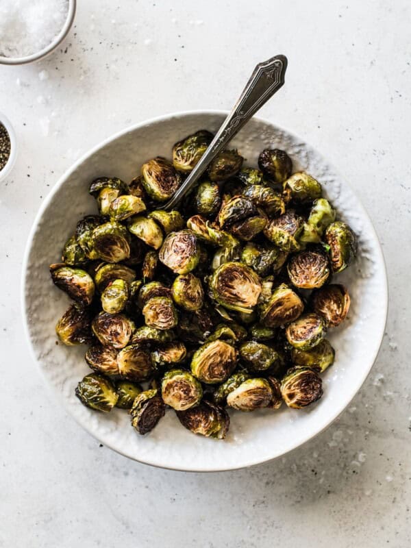 Honey Balsamic Brussel Sprouts in a white bowl topped with sea salt.