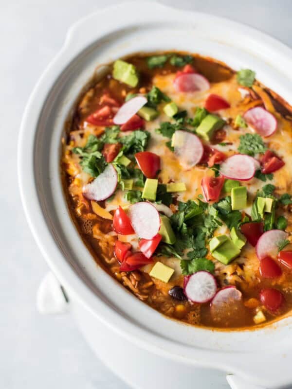 This Slow Cooker Mexican Lasagna is made with layers of black beans, corn tortillas and red enchilada sauce for a delicious gluten free weeknight meal!