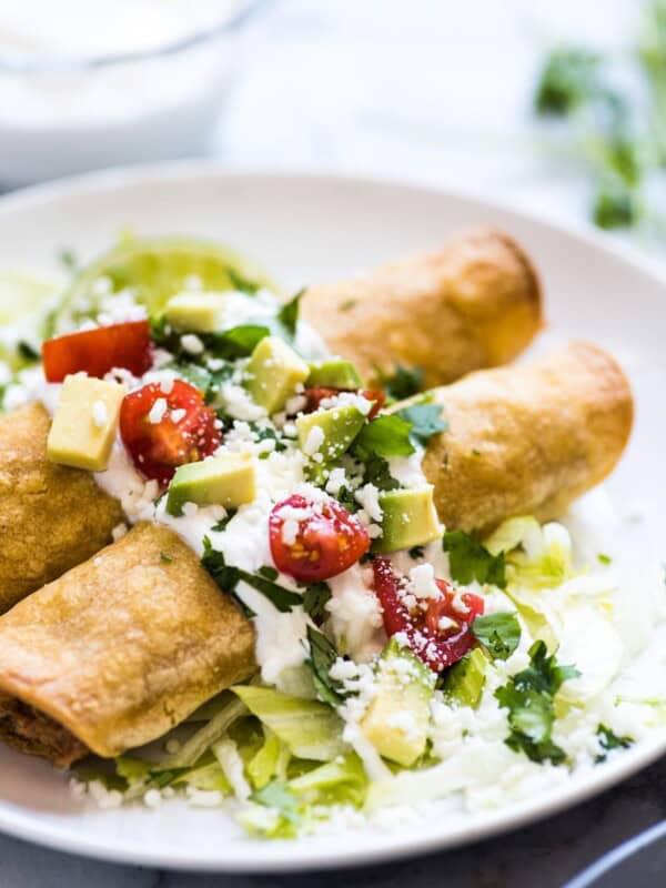 These Baked Chicken Taquitos are stuffed with seasoned shredded chicken, cream cheese, diced green chiles, black beans and corn. Perfect for any weeknight meal! (freezer friendly, gluten free)