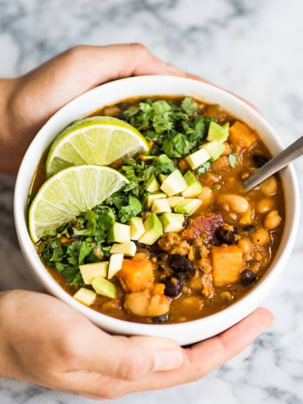 Turkey Pumpkin Chili in a white bowl topped with avocado and cilantro.