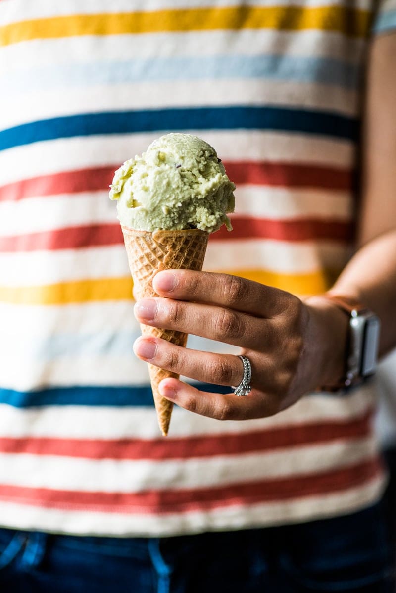 Girl holding avocado ice cream in a sugar cone. | No ice cream maker? No problem! This no churn Avocado Ice Cream is creamy, rich and smooth. All you need is a mixer! (gluten free, vegetarian)