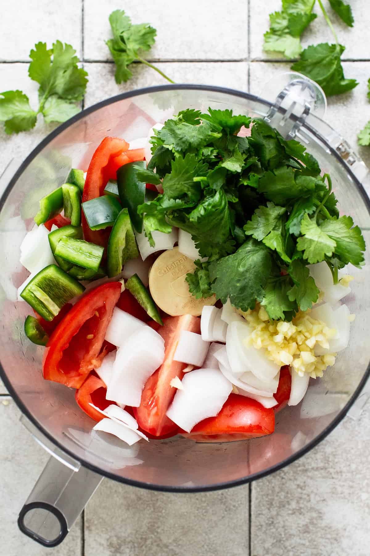 Cilantro, roma tomatoes, onions, garlic, jalapeño, lime juice, and salt in a food processor for homemade salsa.