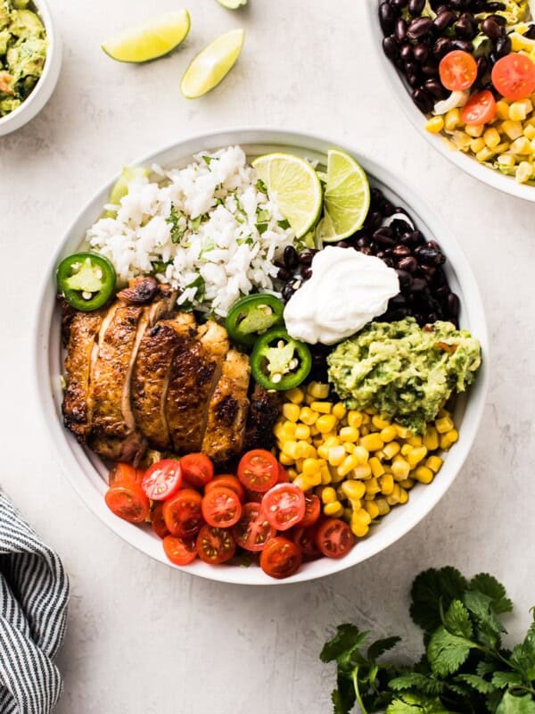 Chicken burrito bowl made with chicken, black beans, cilantro lime rice, corn, tomatoes, guacamole and sour cream.