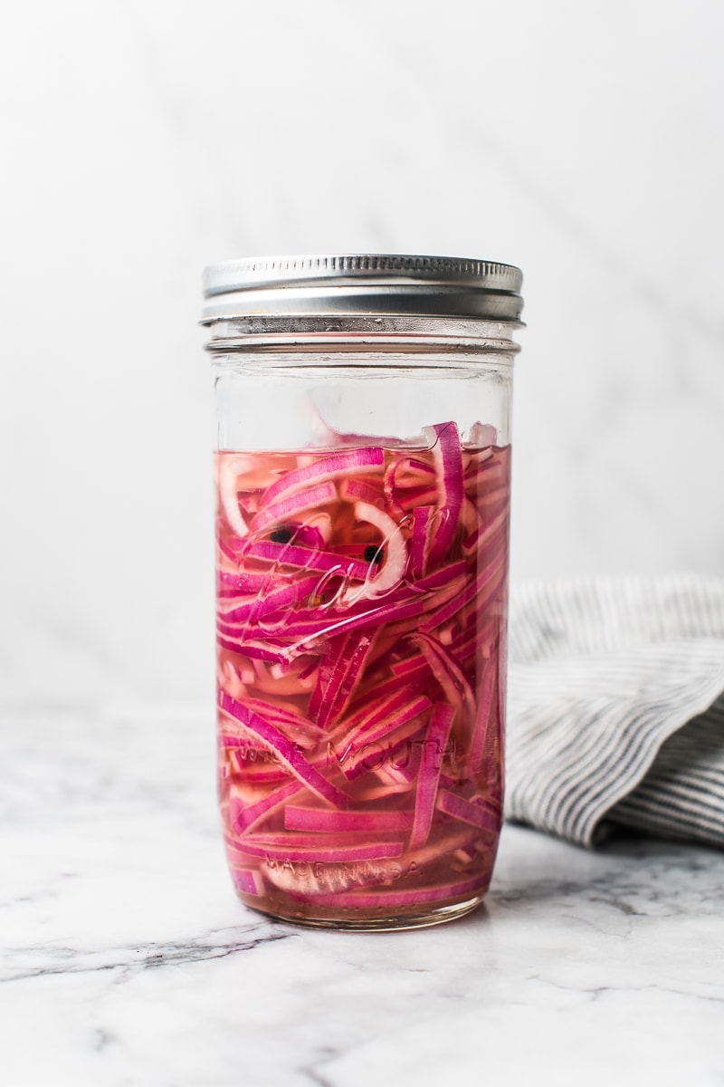 cebolas em pickles bonitas em um frasco de vidro que estão prontos para comer em apenas 30 minutos.