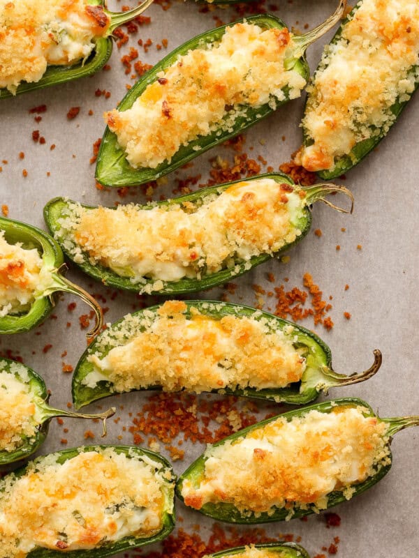 Crispy jalapeno peppers topped with panko breadcrumbs on a baking sheet.