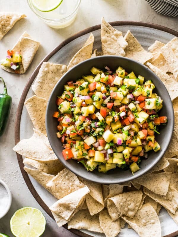 Pineapple salsa in a bowl surrounded by tortilla chips.