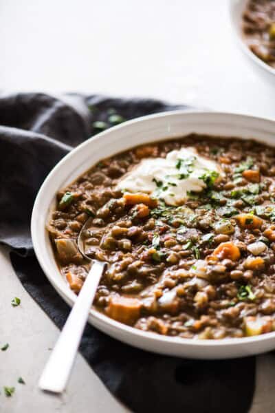 This Crockpot Lentil Soup is easy to make, budget-friendly, hearty and satisfying! Made with dried lentils, chopped vegetables, pantry spices, chipotle peppers in adobo sauce and broth, it's naturally gluten free, vegetarian and vegan. #crockpot #slowcooker #lentilsoup #soup