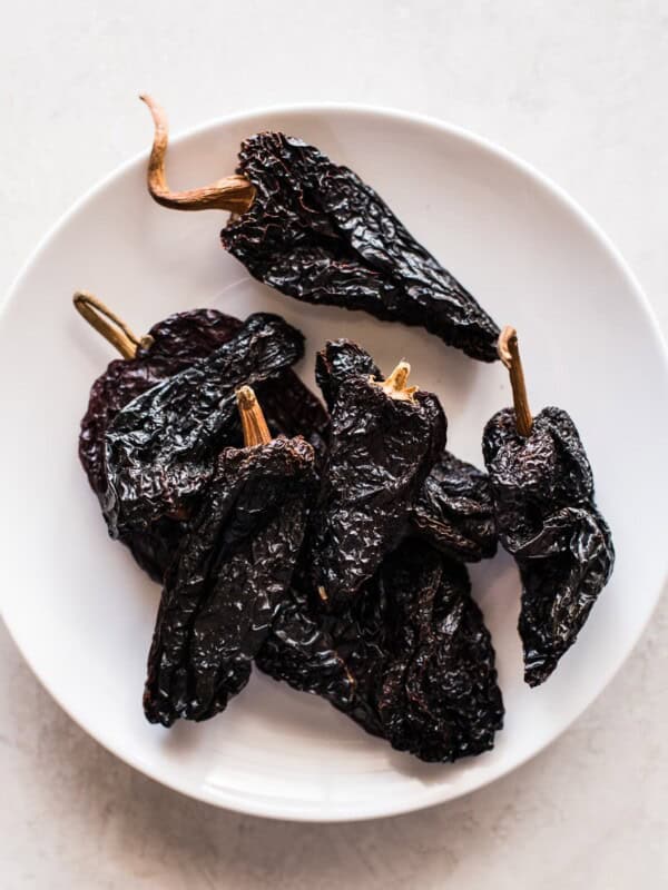 Dried ancho chile peppers on a white plate