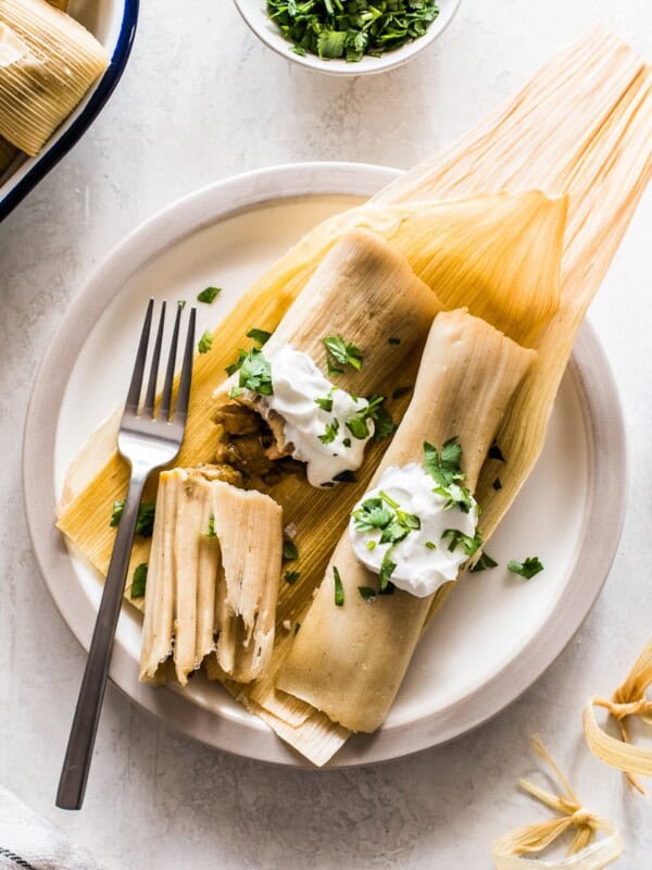 Chicken tamales made from an easy masa tamale dough and stuffed with tender pieces of chicken and green chile verde sauce. Great for serving a crowd or freezing and reheating for later! #tamales #chickentamales #glutenfree #mexicanfood