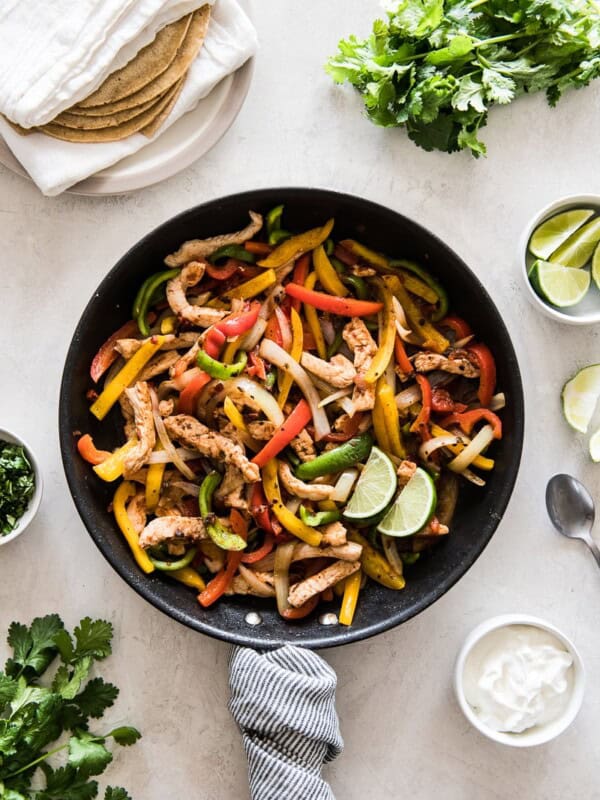 Turkey fajitas in a skillet with bell peppers and onions