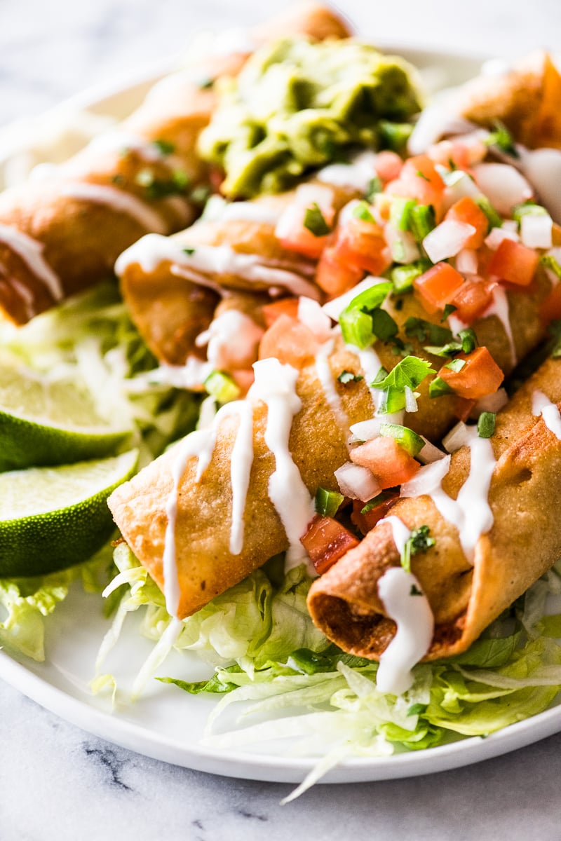 Crispy taquitos filled with chicken and topped with mexican toppings