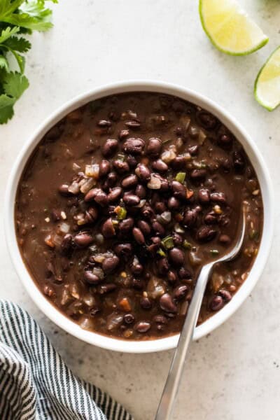 Cooked canned black beans with tomatoes, onions and garlic in a bowl.