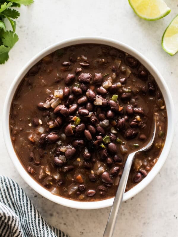 Cooked canned black beans with tomatoes, onions and garlic in a bowl.