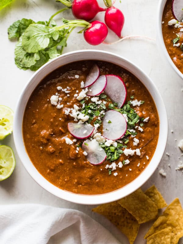 Pinto bean soup garnished with cilantro a cotija cheese.