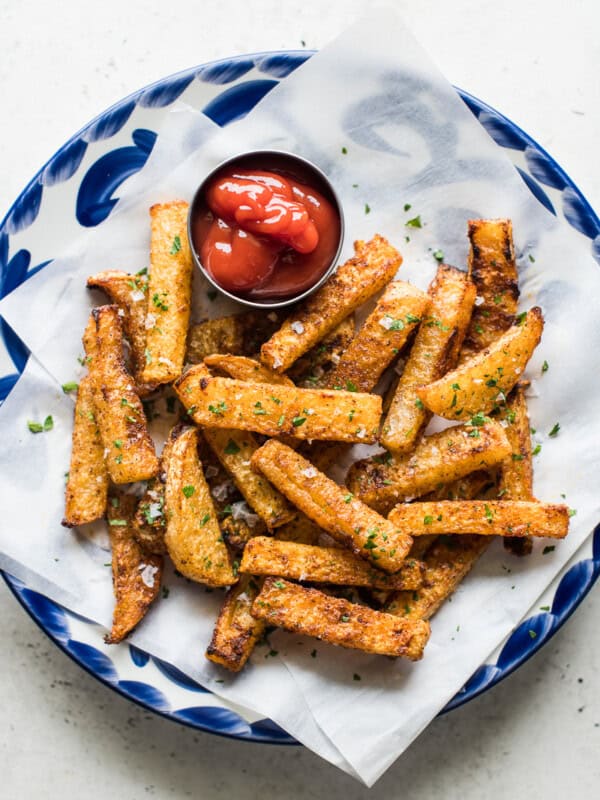 Baked jicama fries on a blue plate with a side of ketchup.