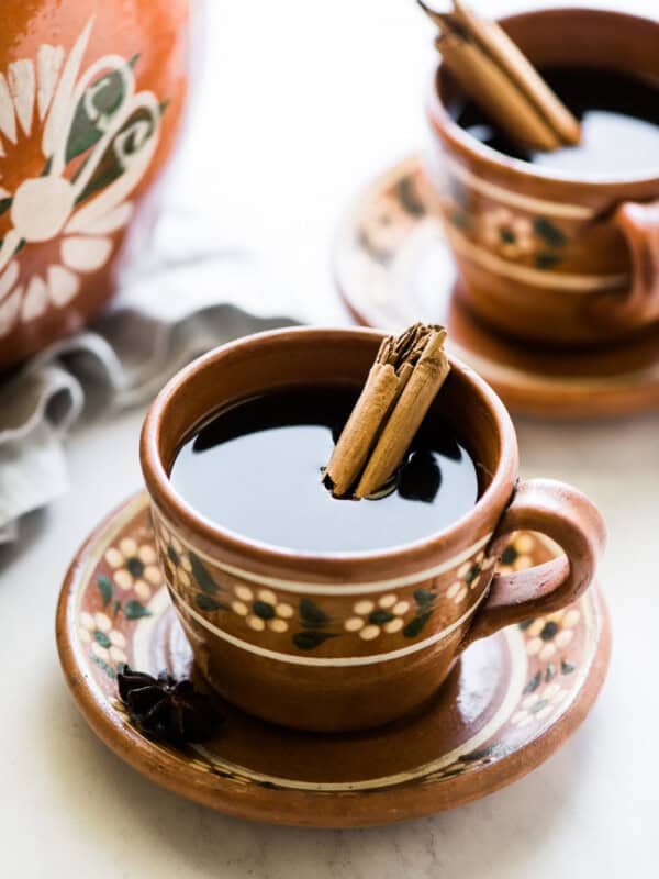 Cafe de olla (traditional Mexican coffee) in a mug with a cinnamon stick.