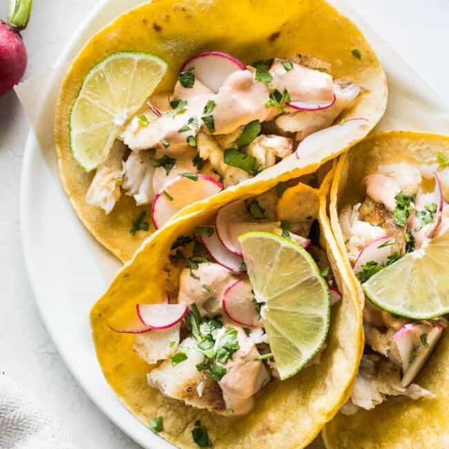 Tilapia fish tacos topped with cilantro and chipotle lime crema.