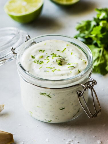 Cilantro lime crema in a jar topped with chopped cilantro.