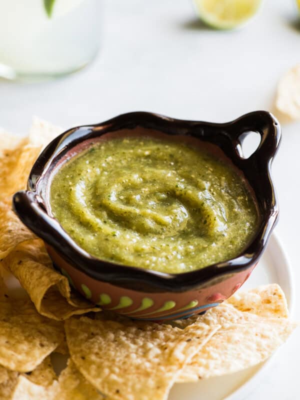 Salsa verde in a Mexican bowl next to some tortilla chips.