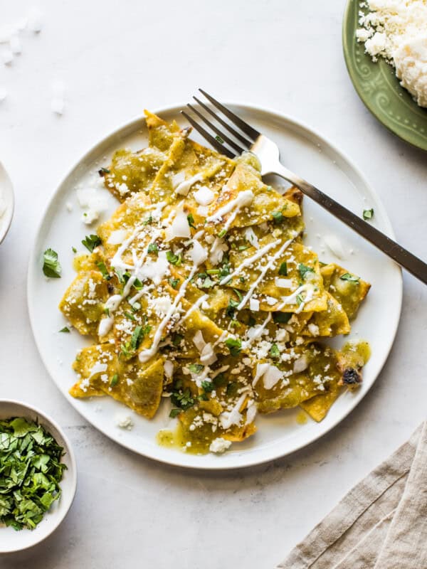 Chilaquiles verdes on a white plate.