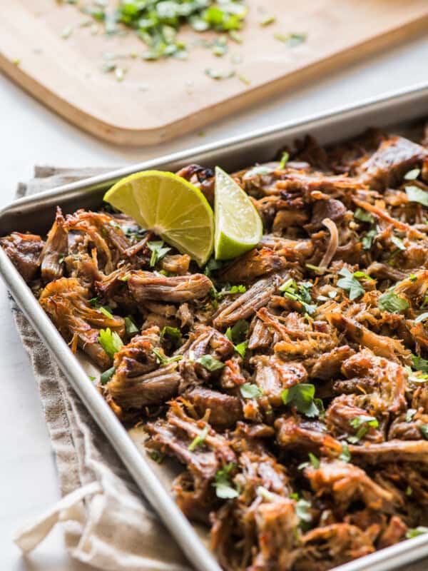 Crispy pressure cooker carnitas topped with cilantro on a baking sheet.