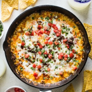 Queso fundido in a skillet with crumbled chorizo.