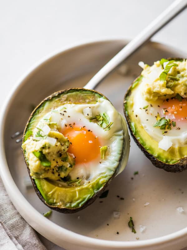 Avocado Egg Bake in a bowl seasoned with salt and pepper.