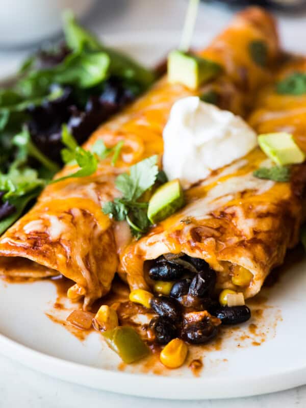 Black bean enchiladas topped with sour cream and cilantro.