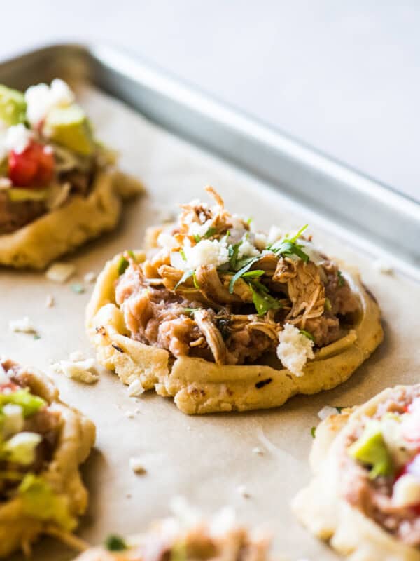 Sopes topped with shredded carnitas and queso fresco.