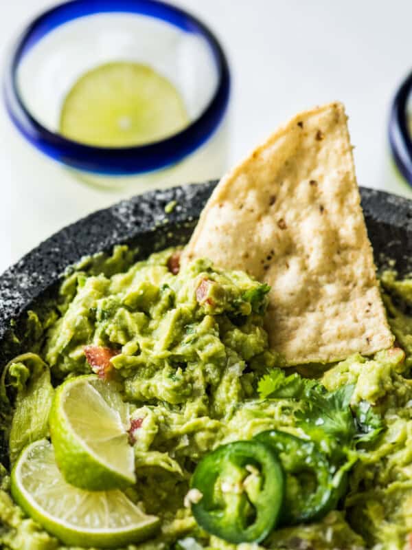 Guacamole in a molcajete with a tortilla chip.