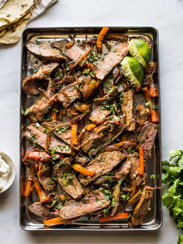 Sheet pan steak fajitas topped with cilantro.