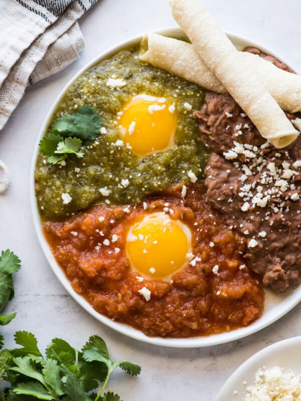 Huevos divorciados on a plate with salsa roja and salsa verde.