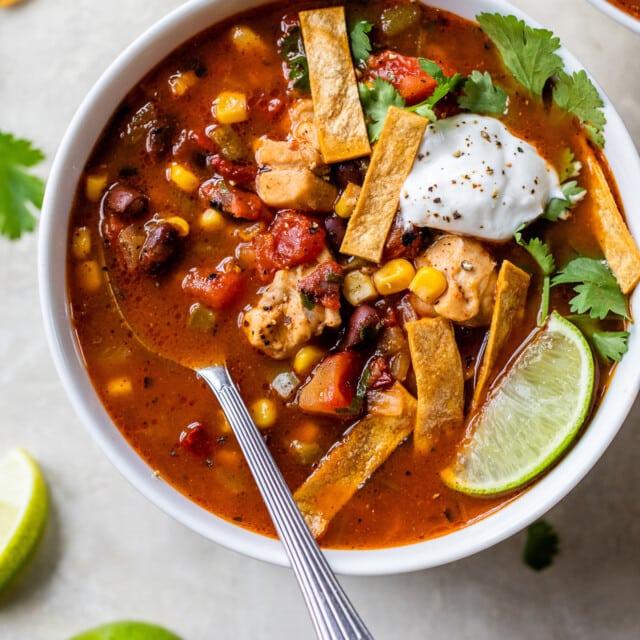 Southwest Chicken Soup ready to be eaten in a bowl served with all the fixings.