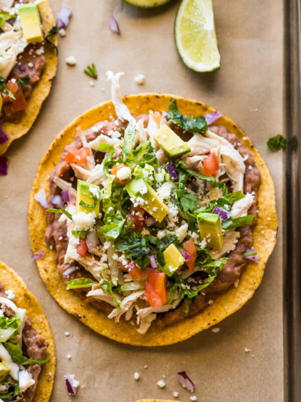 Chicken Tostadas topped with cilantro, cheese, and avocado.