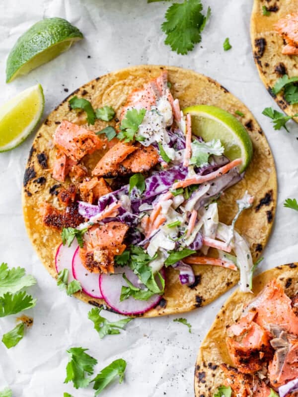 Salmon tacos topped with a creamy slaw and fresh cilantro.