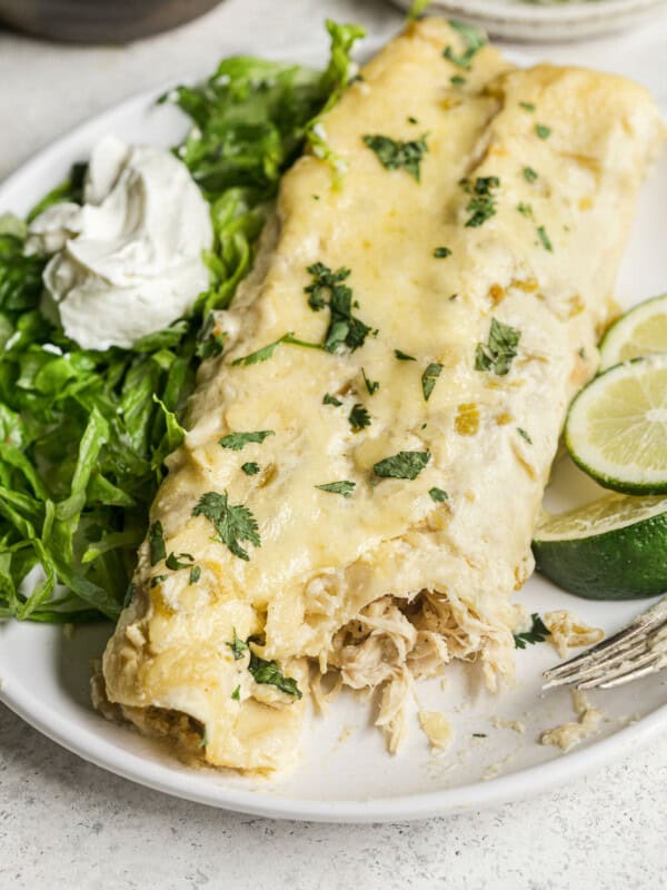 White chicken enchiladas topped with cilantro on a plate.