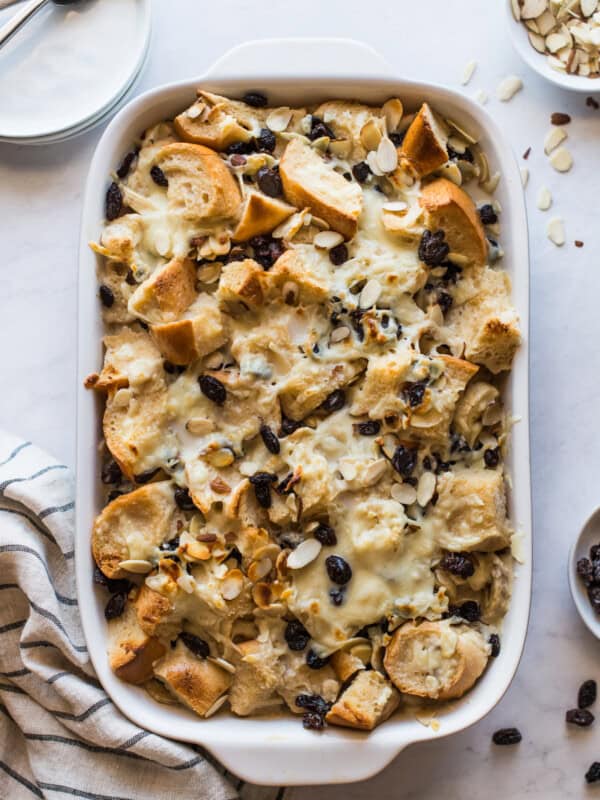 Capirotada (or Mexican Bread Pudding) in a baking dish topped with raisins and cheese.