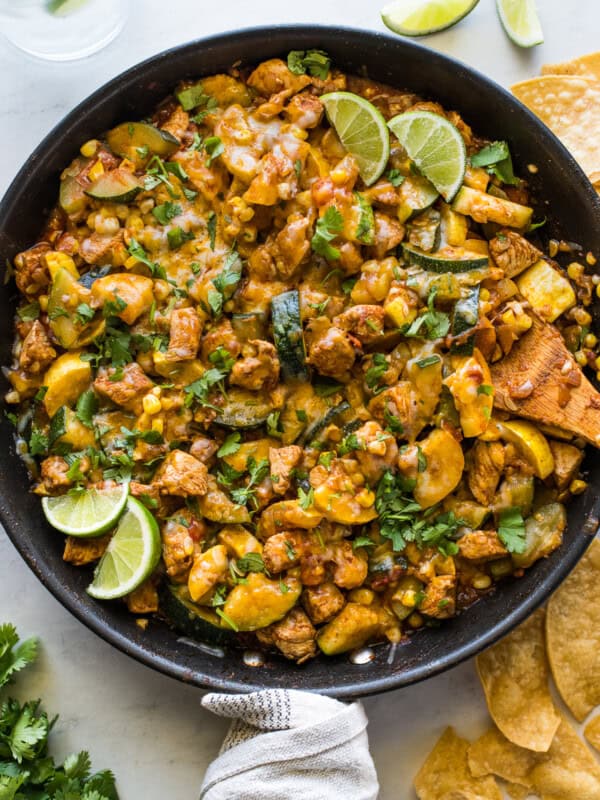 Chicken and Squash in a skillet with cilantro and limes.