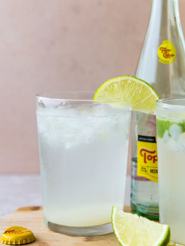 Ranch water drink in a tall glass garnished with a lime wedge.