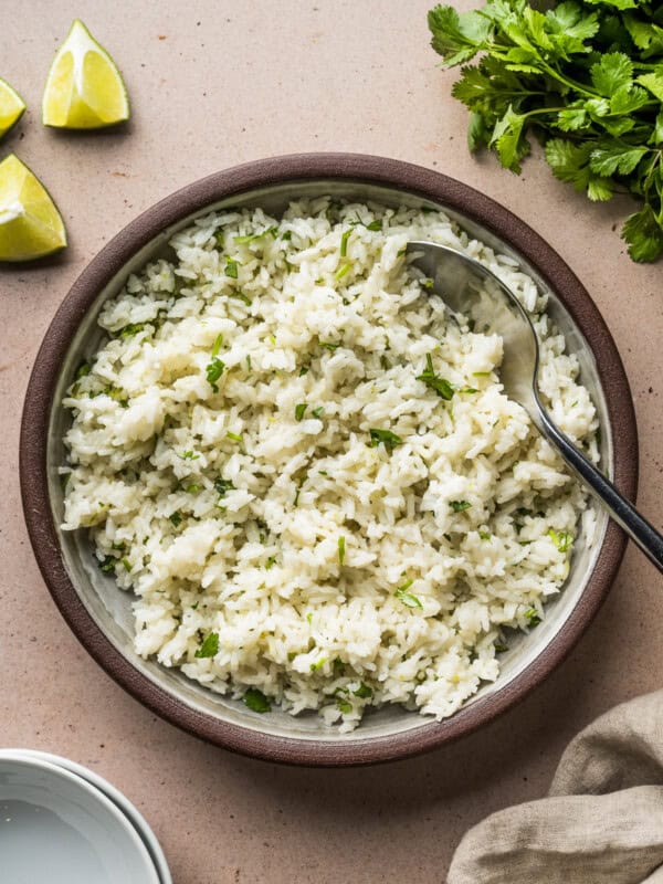 Cilantro lime rice in a serving bowl garnished with chopped cilantro.