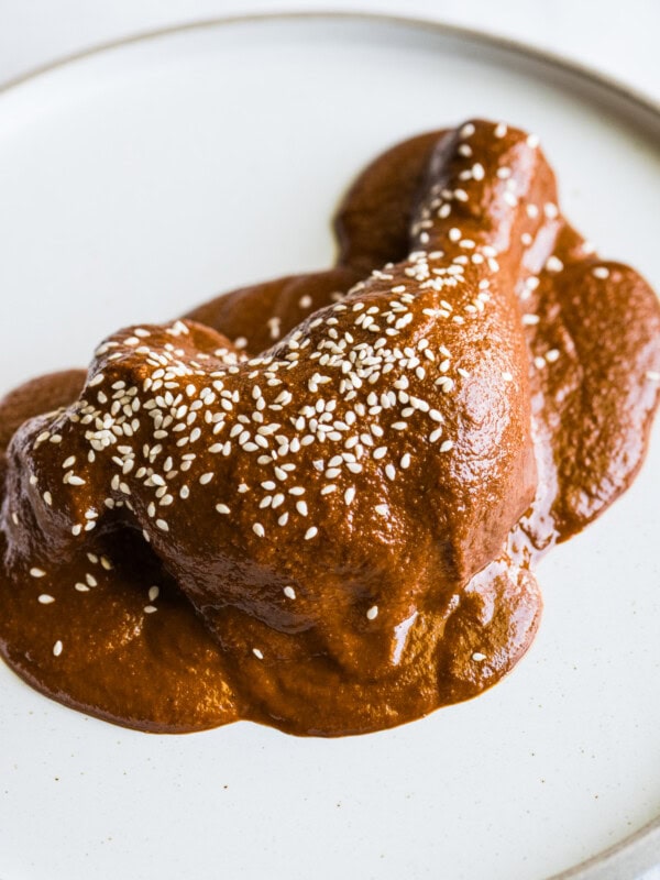 Mole sauce on chicken garnished with sesame seeds.