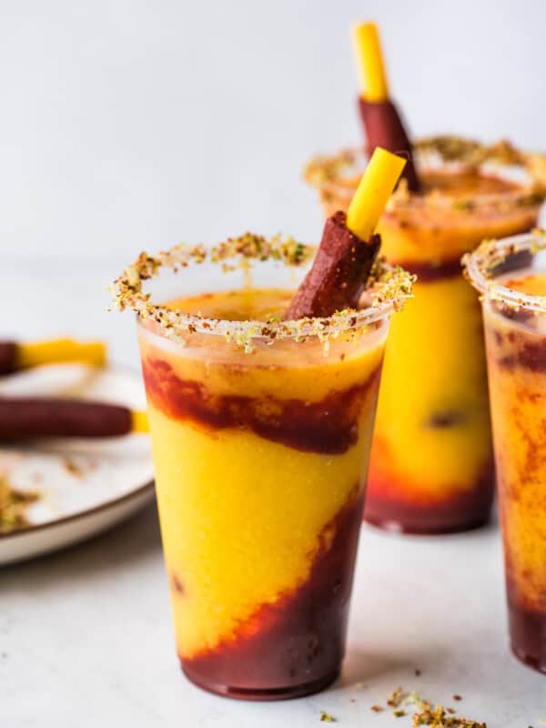 Mangonadas in clear plastic cups with a tamarind candy straws.