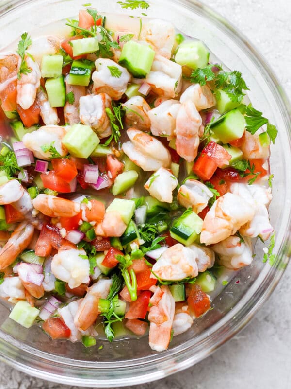 A bowl of ceviche made with shrimp, avocado, tomatoes, cilantro, red onion, and citrus juices.