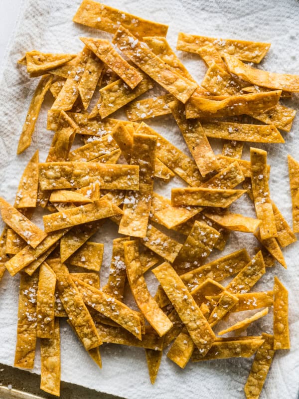 Crispy tortilla strips on a baking sheet lined with paper towels.