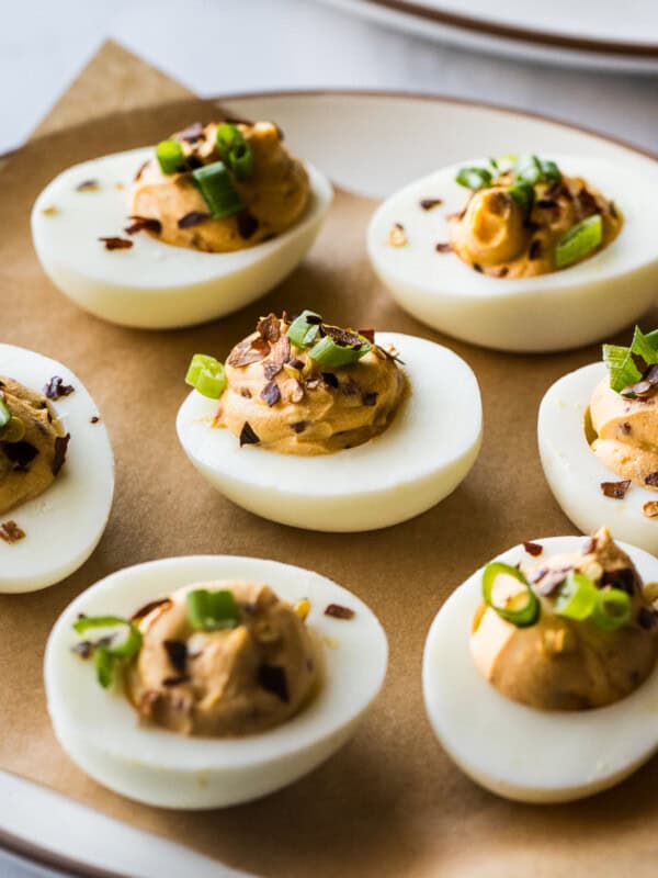 Spicy deviled eggs on a plate garnished and ready to be eaten.