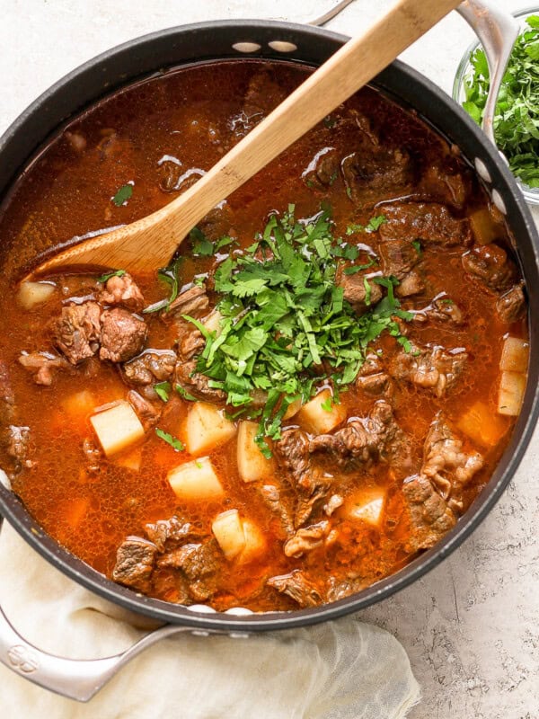 Carne con papas in a pot with cilantro stirred in.