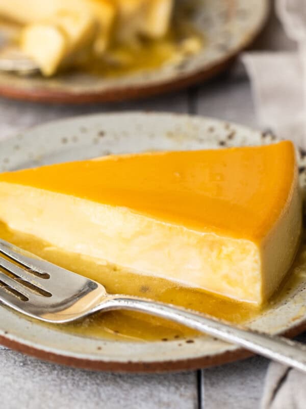 Flan de queso with caramel sauce on a plate.