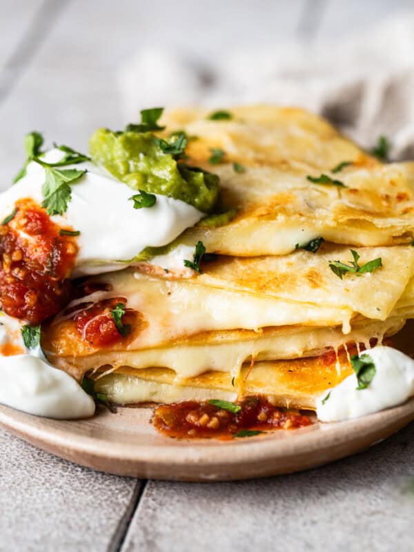 Cheese quesadillas on a plate stacked on top of each other.