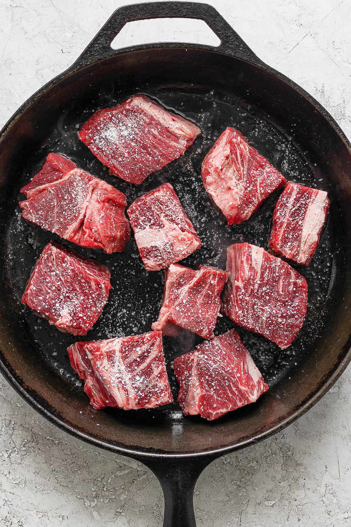 Seasoned beef placed  on a skillet