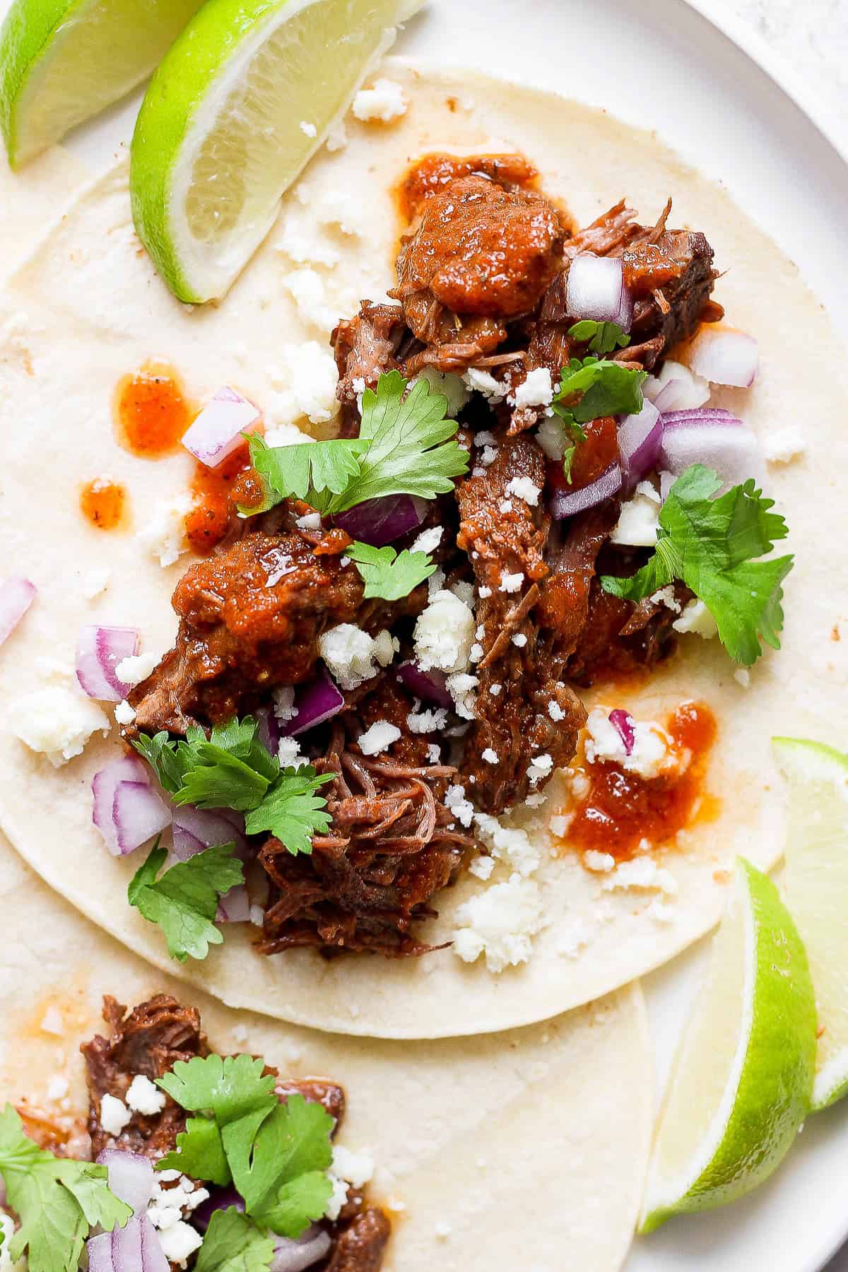 Beef tinga served as a taco with toppings